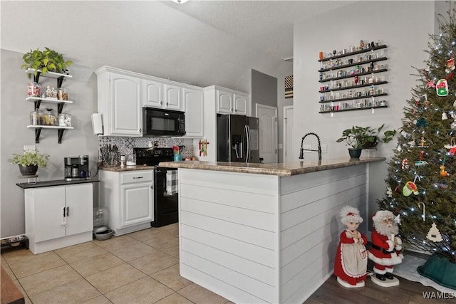 kitchen featuring decorative backsplash, kitchen peninsula, black appliances, white cabinets, and light tile patterned flooring