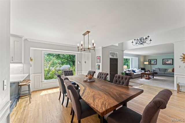 dining room featuring crown molding, light hardwood / wood-style flooring, and ceiling fan with notable chandelier