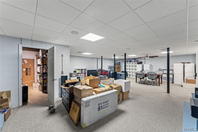 basement with carpet, a paneled ceiling, and white refrigerator