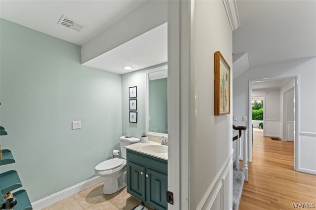 bathroom with hardwood / wood-style floors, vanity, and toilet