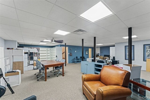 carpeted office space with a paneled ceiling and ceiling fan