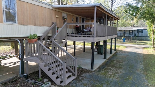 wooden terrace featuring a patio and stairs