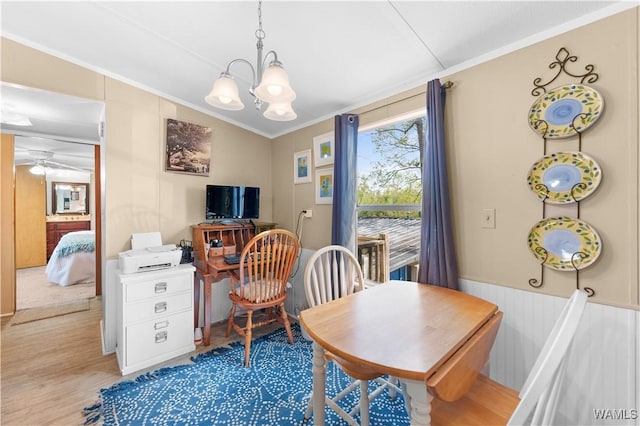 office area with ceiling fan with notable chandelier, wainscoting, crown molding, and wood finished floors