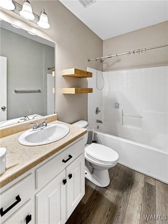1902 45th Ave, Northport, AL 35476 - bathroom featuring shower / washtub combination, visible vents, toilet, vanity, and wood finished floors