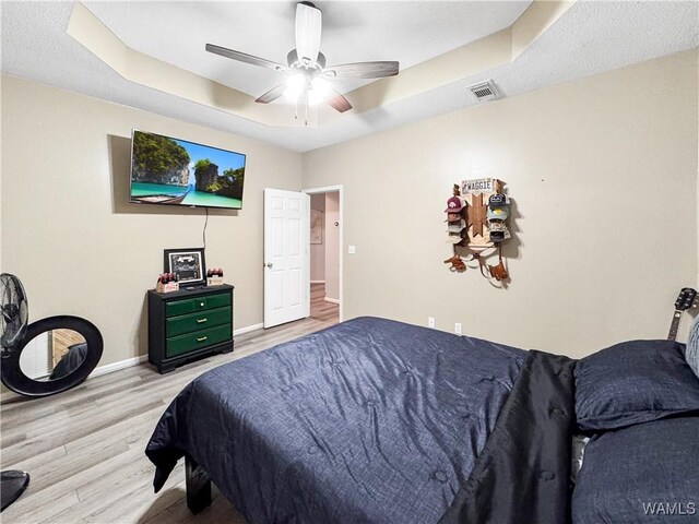 1902 45th Ave, Northport, AL 35476 - bedroom with wood finished floors, a ceiling fan, visible vents, baseboards, and a tray ceiling