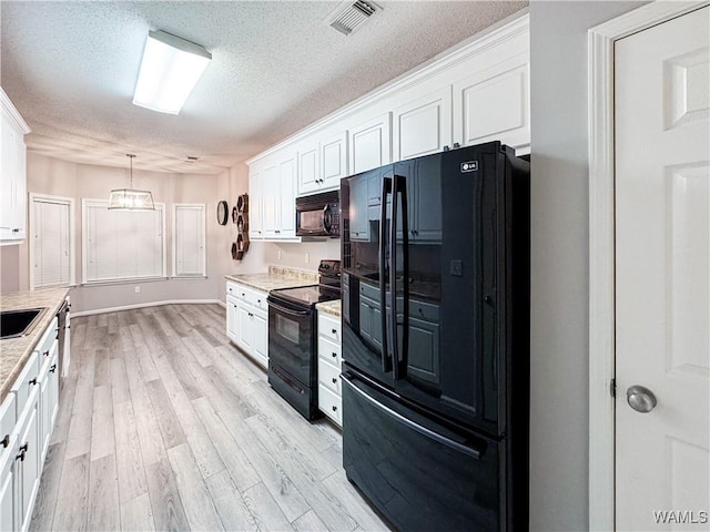 1902 45th Ave, Northport, AL 35476 - kitchen with black appliances, light wood-type flooring, light countertops, and white cabinets
