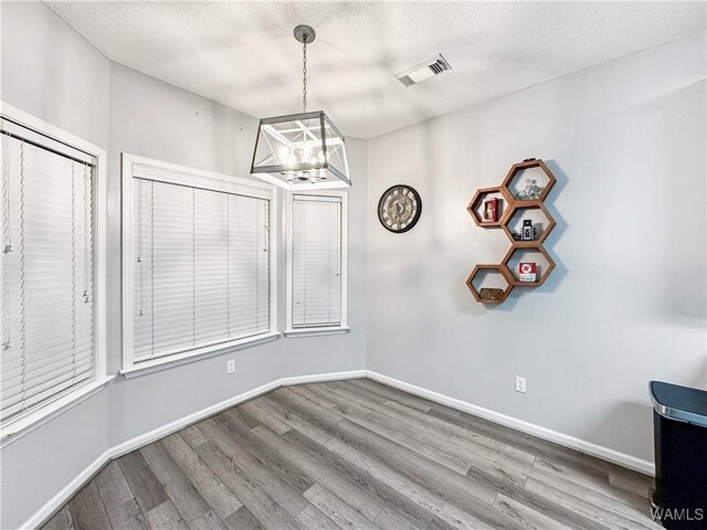 1902 45th Ave, Northport, AL 35476 - unfurnished dining area with a textured ceiling, wood finished floors, visible vents, and baseboards