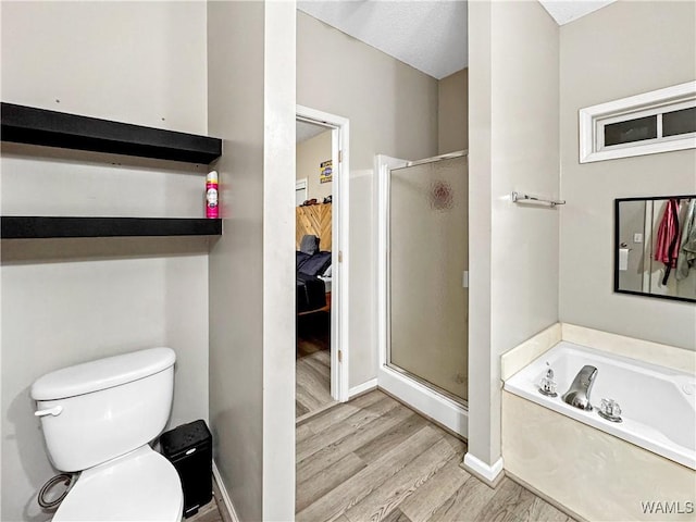 1902 45th Ave, Northport, AL 35476 - bathroom with toilet, wood finished floors, baseboards, a shower stall, and a bath