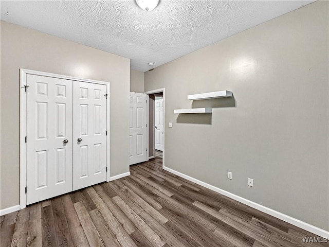 1902 45th Ave, Northport, AL 35476 - unfurnished bedroom featuring a textured ceiling, a closet, wood finished floors, and baseboards