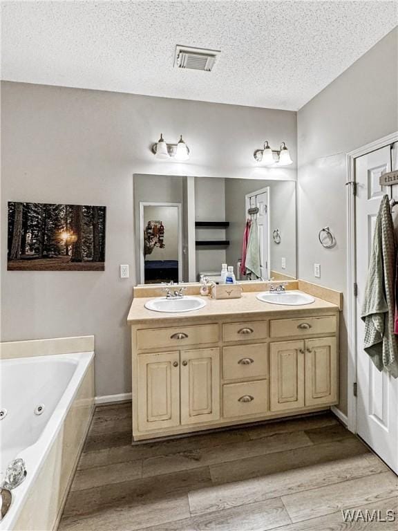 1902 45th Ave, Northport, AL 35476 - bathroom featuring double vanity, visible vents, a sink, and wood finished floors