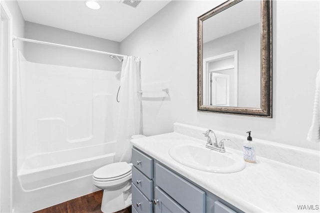 full bath with visible vents, toilet, wood finished floors, shower / bath combination with curtain, and vanity