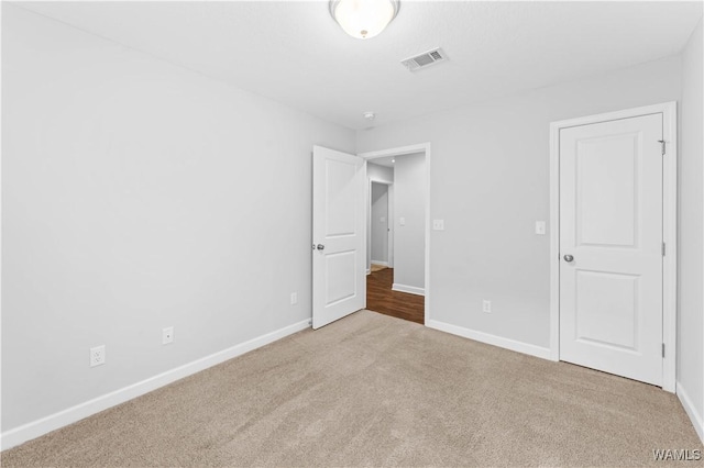 unfurnished bedroom with carpet flooring, visible vents, and baseboards