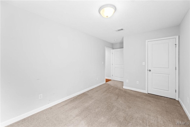 unfurnished bedroom with carpet, visible vents, and baseboards