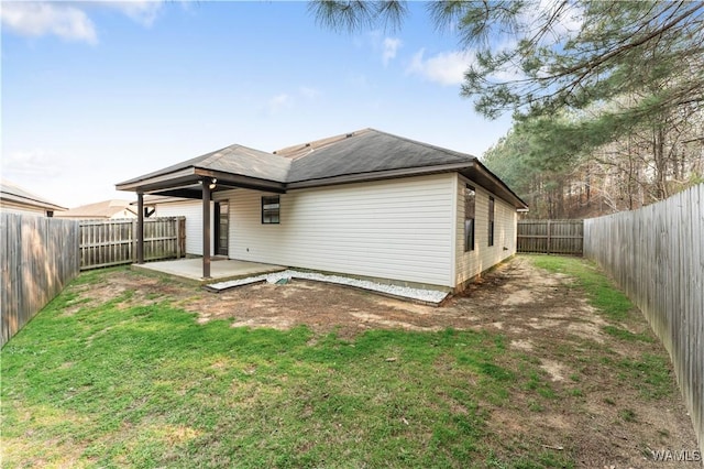 back of property with a patio area, a fenced backyard, and a yard