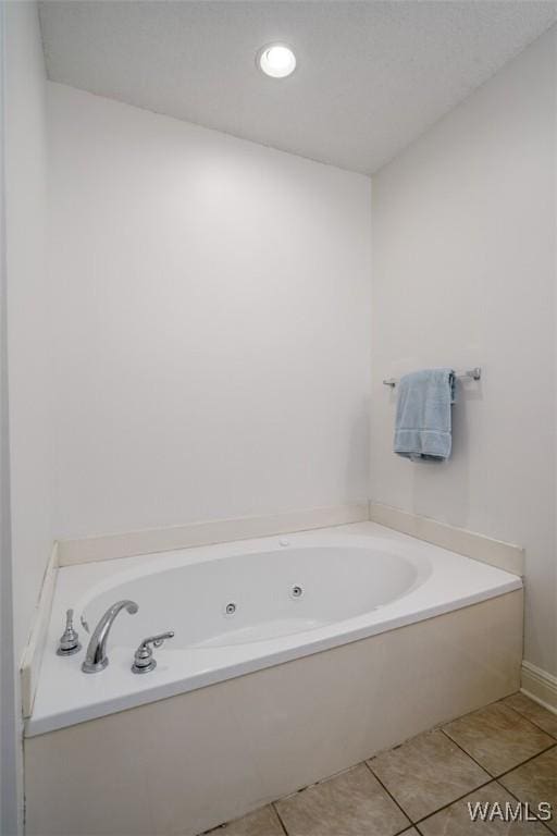 bathroom with tile patterned floors and a tub to relax in