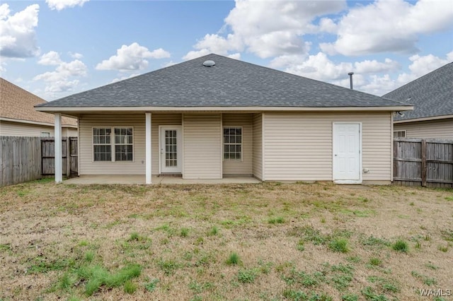 back of house featuring a lawn and a patio area