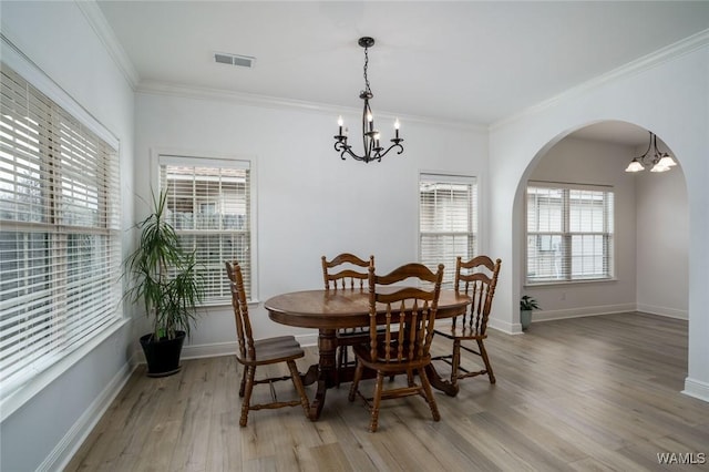 dining area featuring ornamental molding, a chandelier, and light hardwood / wood-style floors