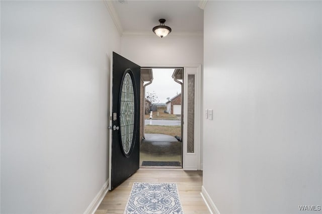 entryway featuring ornamental molding and light hardwood / wood-style flooring