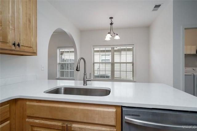 kitchen featuring dishwasher, washer / dryer, sink, and decorative light fixtures