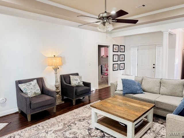 living room featuring wood-type flooring, decorative columns, ceiling fan, and crown molding