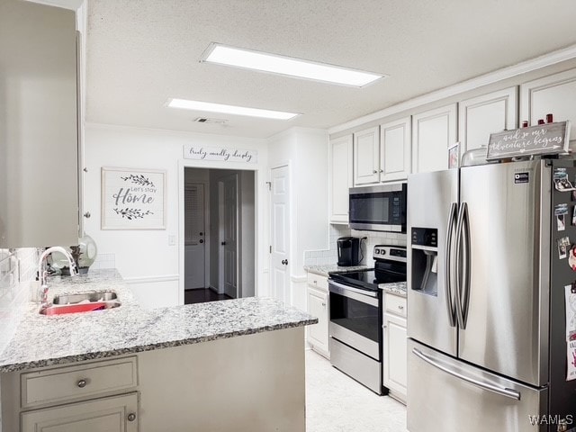 kitchen with kitchen peninsula, stainless steel appliances, white cabinetry, and sink