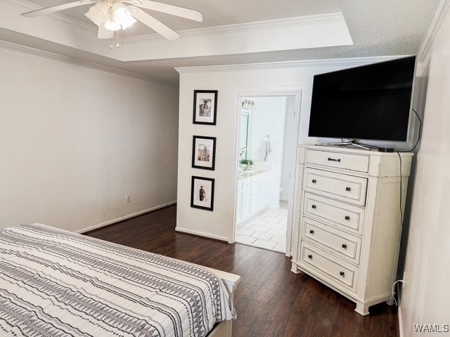 bedroom featuring ensuite bath, crown molding, dark hardwood / wood-style flooring, and ceiling fan