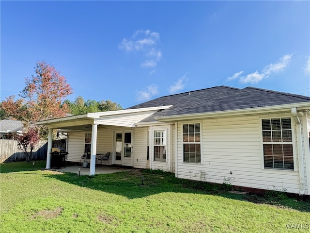 back of house featuring a lawn and a patio area