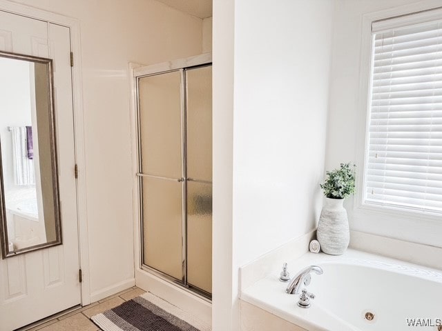 bathroom featuring independent shower and bath, tile patterned flooring, and a healthy amount of sunlight