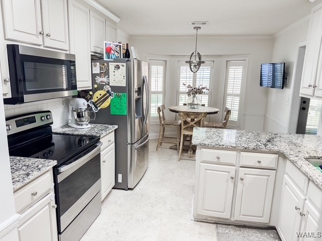 kitchen featuring an inviting chandelier, white cabinets, hanging light fixtures, decorative backsplash, and appliances with stainless steel finishes