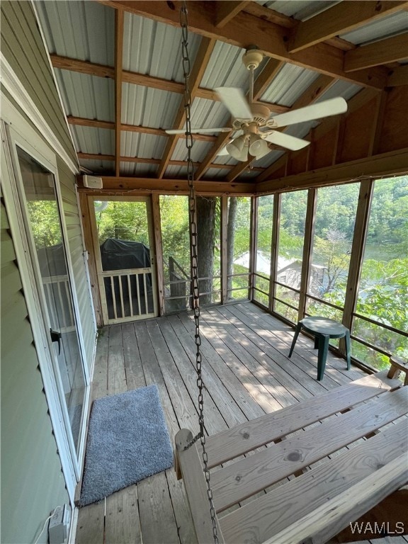 unfurnished sunroom featuring vaulted ceiling with beams and ceiling fan