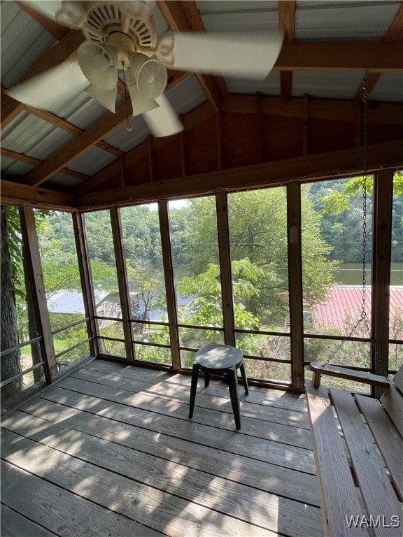 unfurnished sunroom featuring vaulted ceiling with beams and ceiling fan