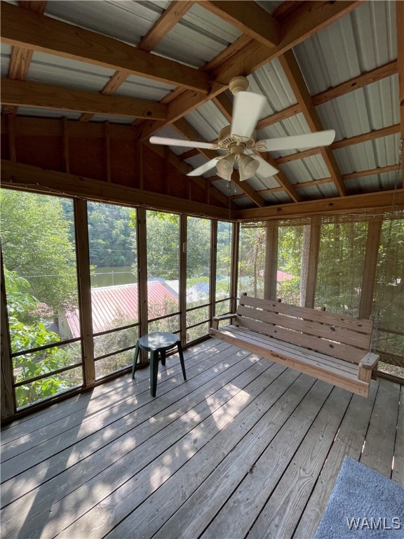 unfurnished sunroom with vaulted ceiling with beams and ceiling fan