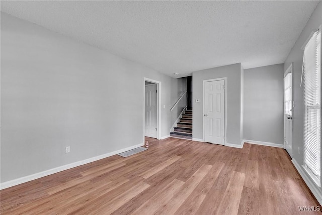 1713 Serene Cir, Centerpoint, AL 35215 - spare room featuring stairs, light wood-style flooring, plenty of natural light, and a textured ceiling