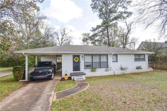 ranch-style home with a front lawn, driveway, an attached carport, fence, and brick siding