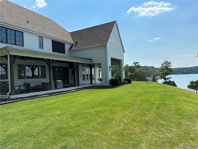 rear view of property with a yard and a water view