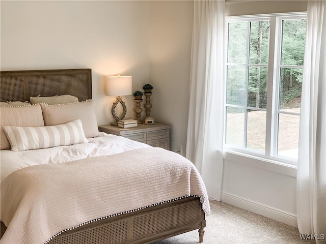 bedroom featuring light colored carpet and multiple windows