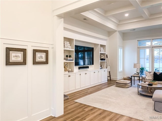 living room with hardwood / wood-style flooring, built in features, beam ceiling, and coffered ceiling