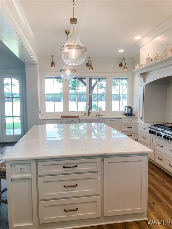 kitchen with decorative light fixtures, plenty of natural light, and white cabinetry