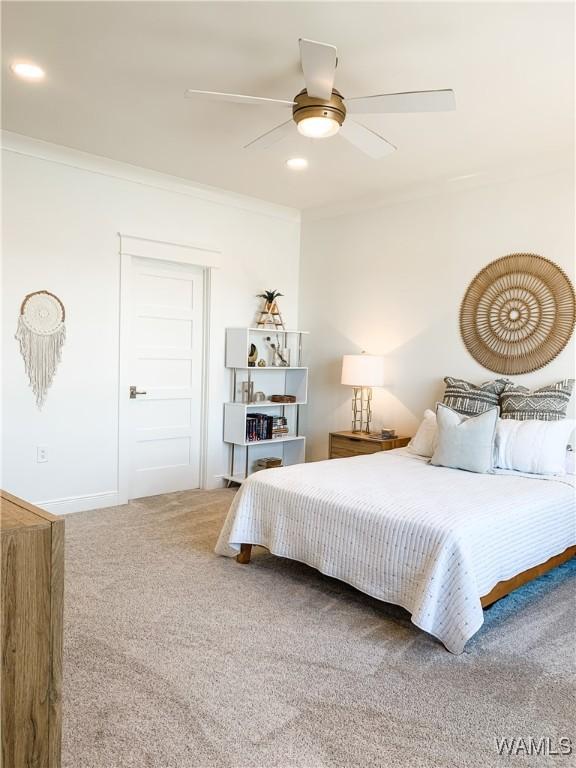 carpeted bedroom featuring ceiling fan and ornamental molding