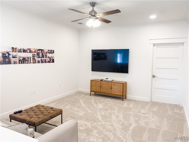 carpeted living room featuring ceiling fan and crown molding