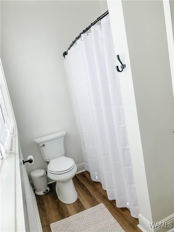 bathroom featuring toilet and wood-type flooring