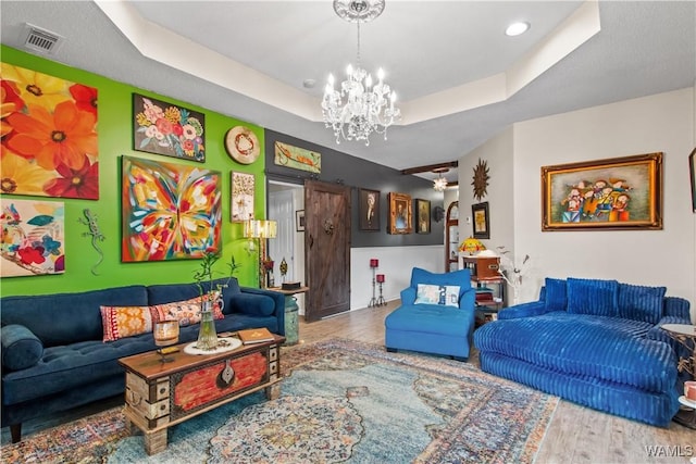 4468 21st St, Northport, AL 35476 - living room featuring a chandelier, a tray ceiling, and wood finished floors