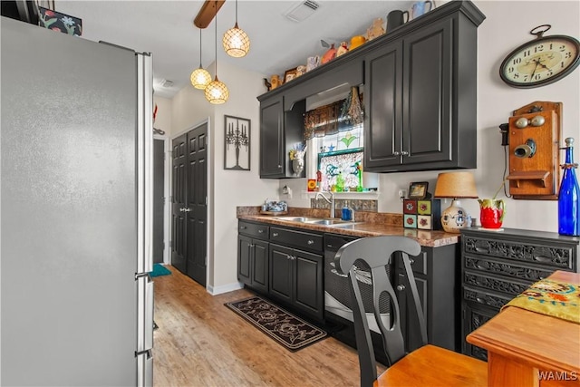 4468 21st St, Northport, AL 35476 - kitchen with freestanding refrigerator, a sink, light wood-type flooring, and dark cabinetry