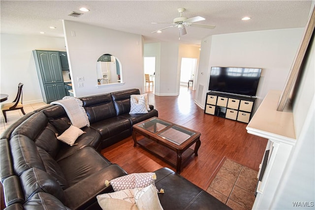 living area featuring recessed lighting, visible vents, dark wood finished floors, and a textured ceiling