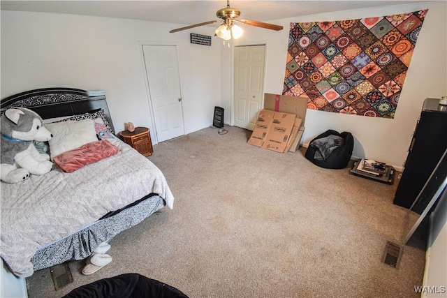 carpeted bedroom featuring ceiling fan and a closet