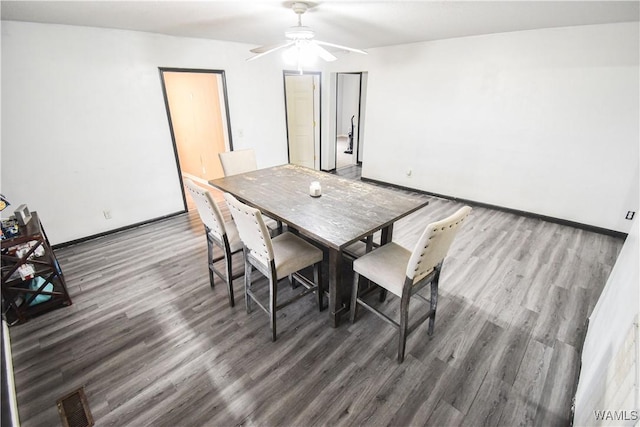 dining room with dark hardwood / wood-style flooring and ceiling fan