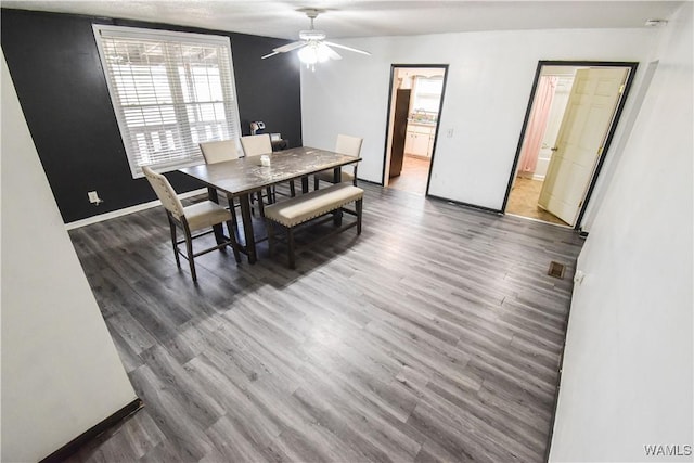 dining space with dark hardwood / wood-style floors and ceiling fan