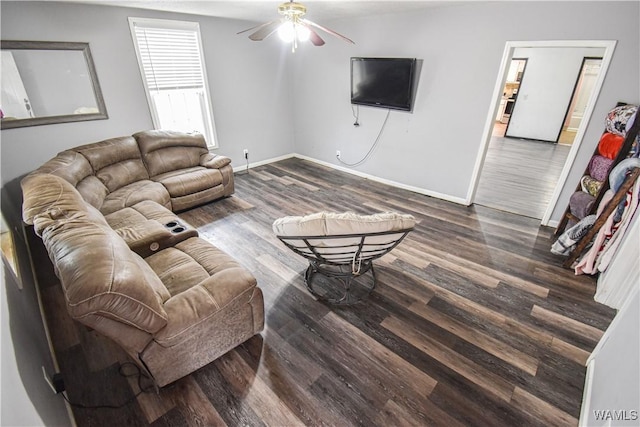 living room featuring dark wood-type flooring and ceiling fan