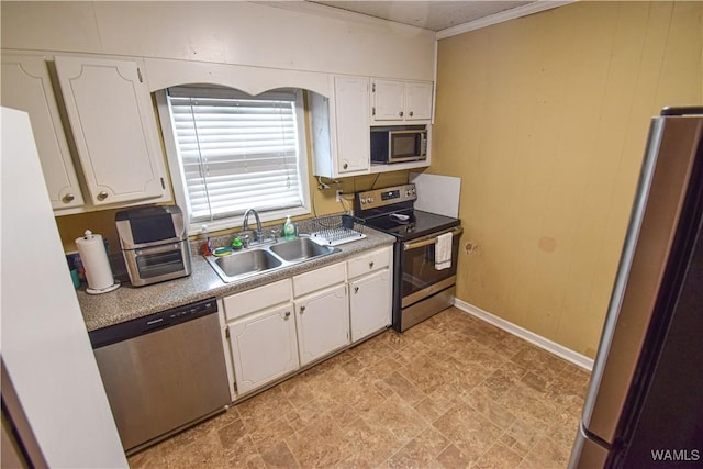 kitchen with stainless steel appliances, white cabinetry, sink, and crown molding