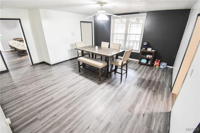 dining space with wood-type flooring and ceiling fan